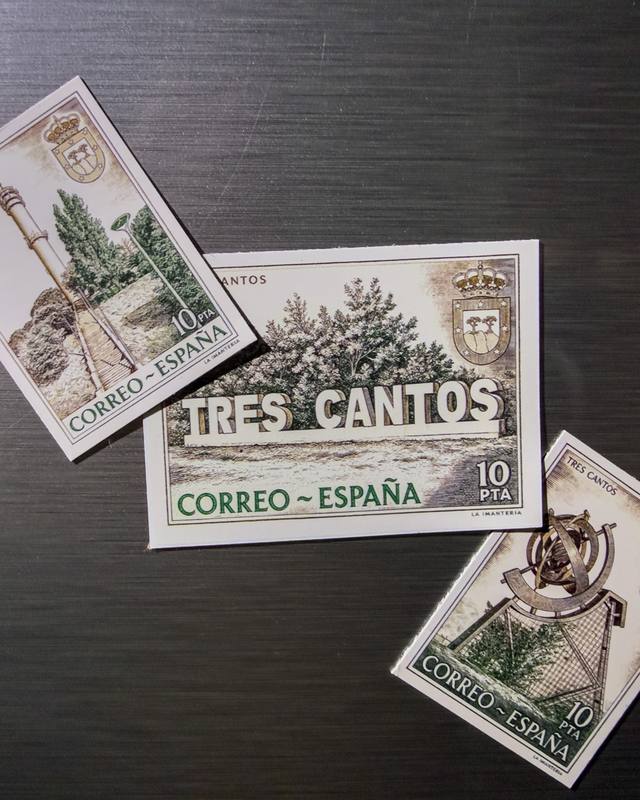 Tres imanes con sellos de rincones de Tres Cantos sobre una nevera